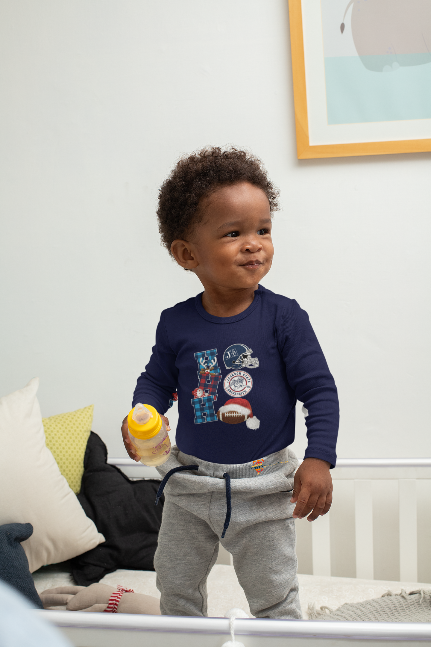 Infant long sleeve bodysuit in navy with football and team logo, worn with gray pants