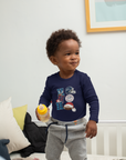 Infant long sleeve bodysuit in navy with football and team logo, worn with gray pants