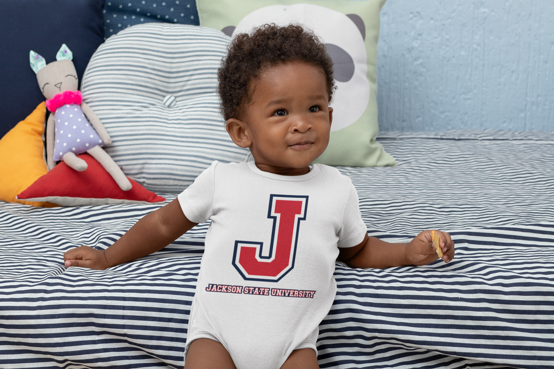 Infant wearing tri-color baseball jersey bodysuit with large J logo and university text