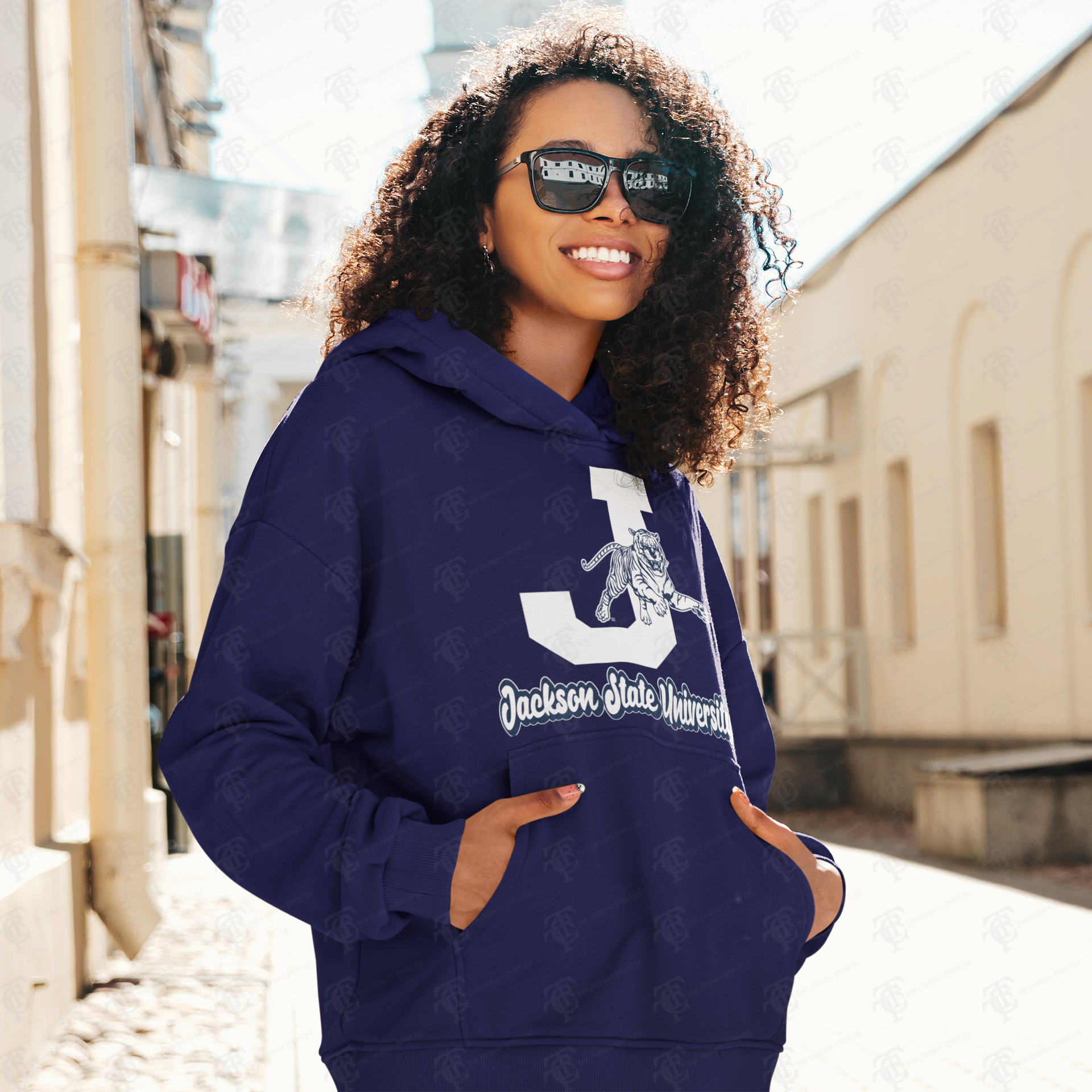Navy pullover hoodie on person with white J and leaping tiger graphic on front