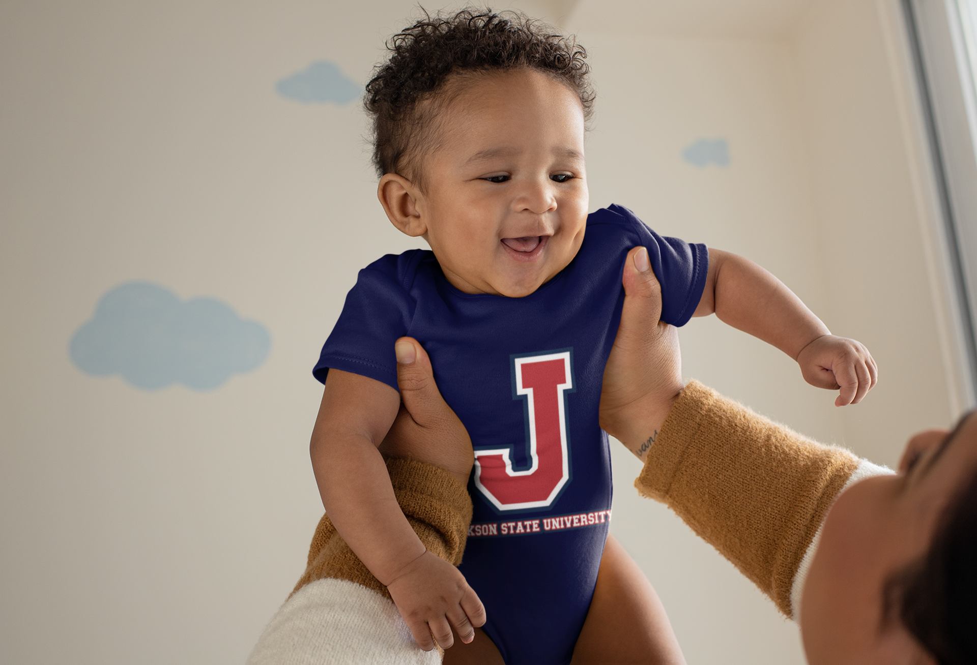 Infant wearing navy short sleeve bodysuit with J logo and Jackson State University print