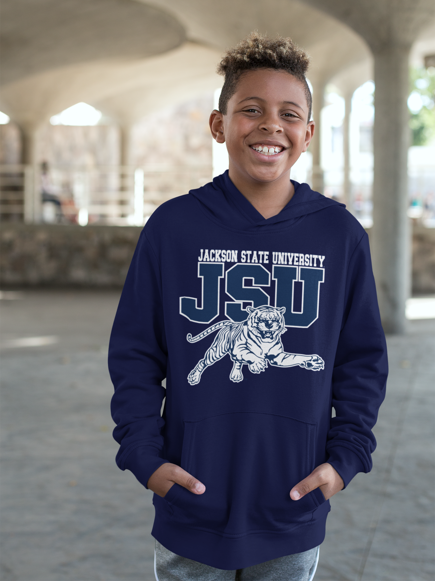Youth unisex navy hoodie worn by child, featuring JSU tiger logo on the front