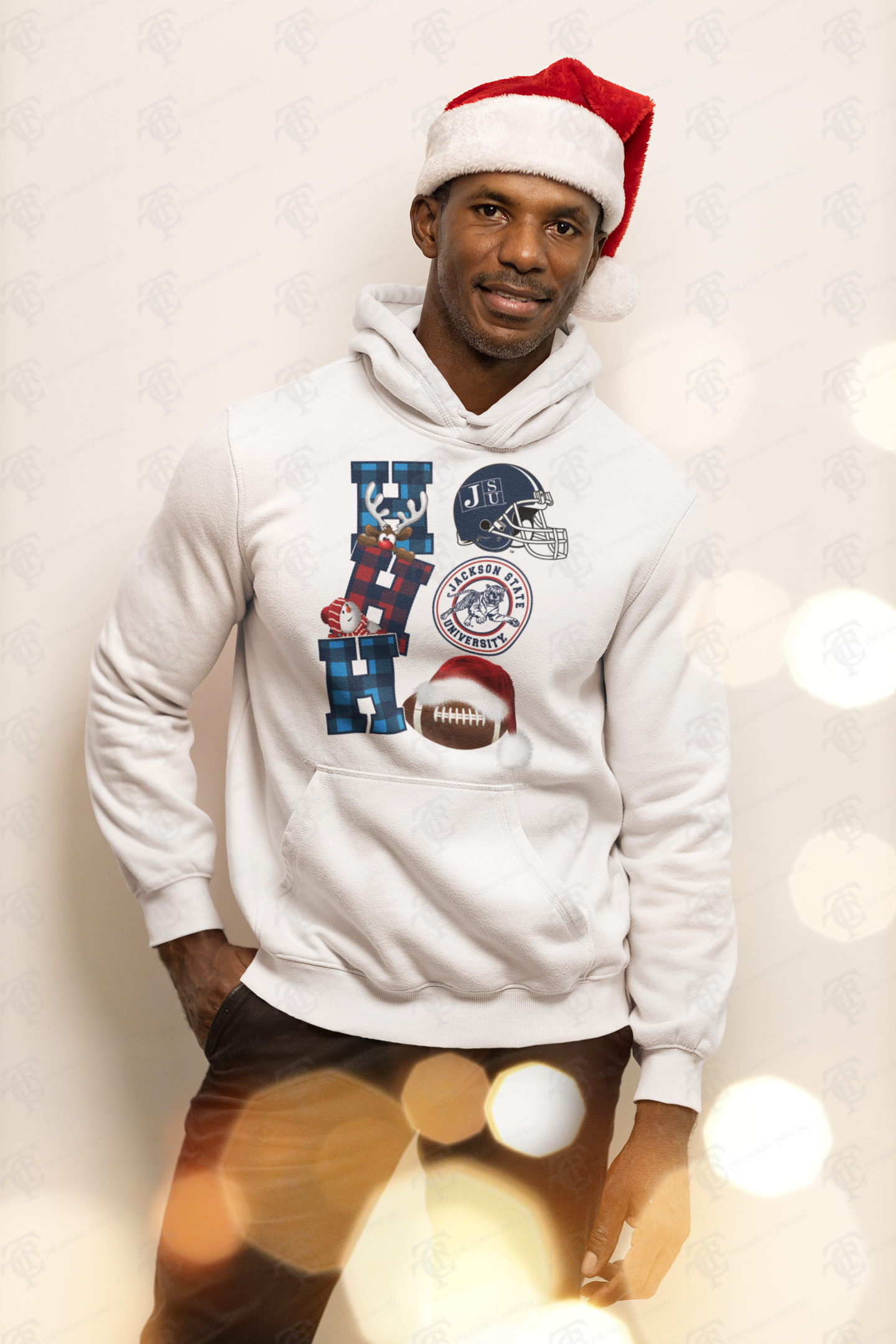 Cream unisex pullover hoodie with holiday graphic and team logo on front, worn by model