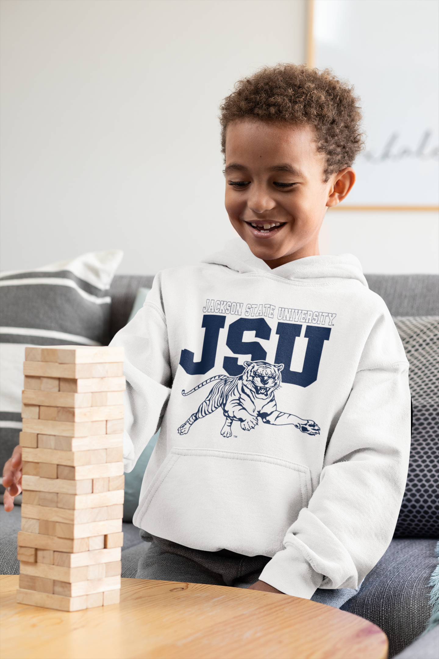 Youth unisex white hoodie worn by child, featuring JSU tiger logo on the front