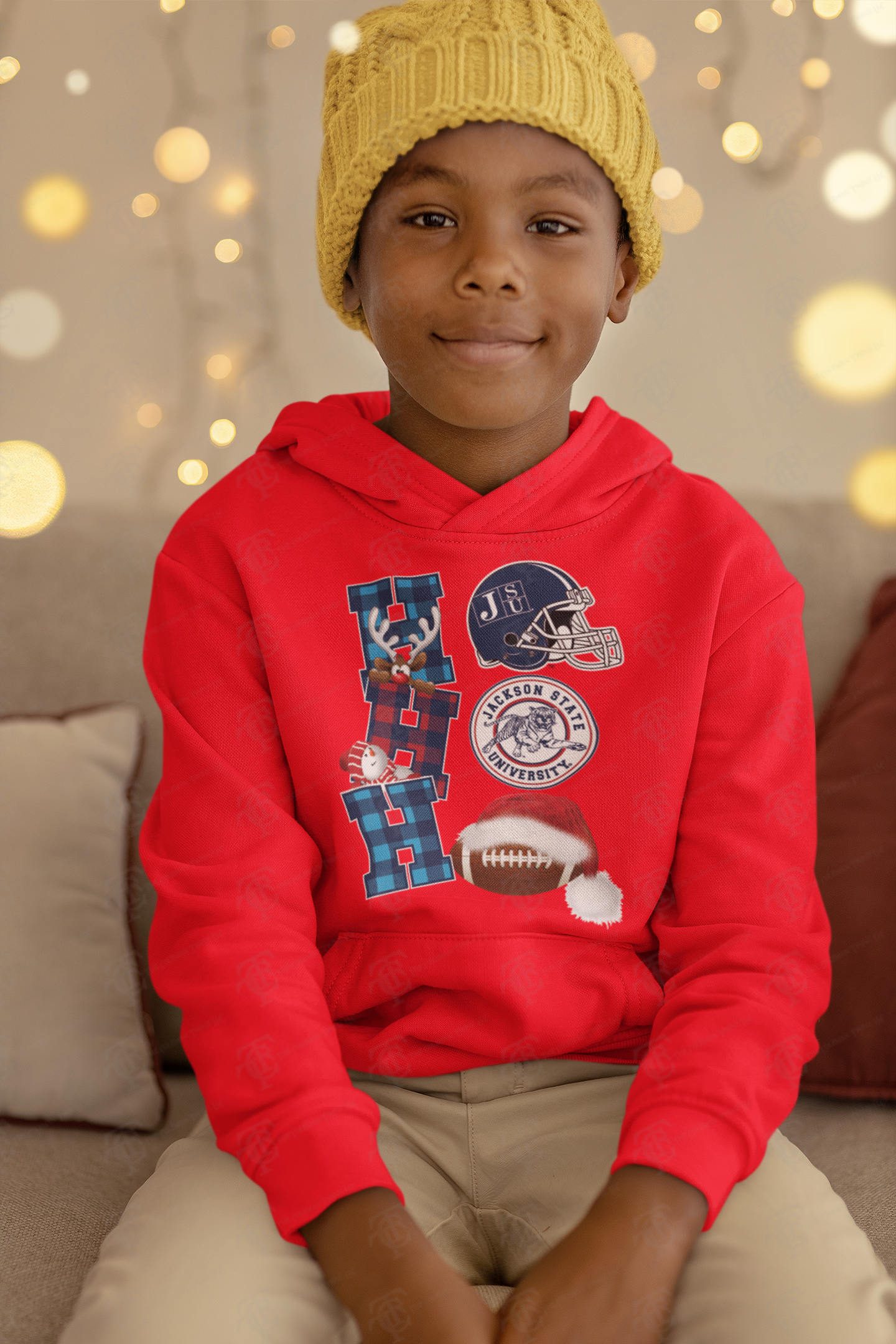 Red youth pullover hoodie worn by a child, featuring team graphic and football with white pom