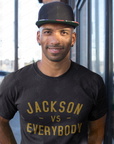 Black short sleeve crewneck T-shirt with gold “JACKSON vs EVERYBODY” lettering.