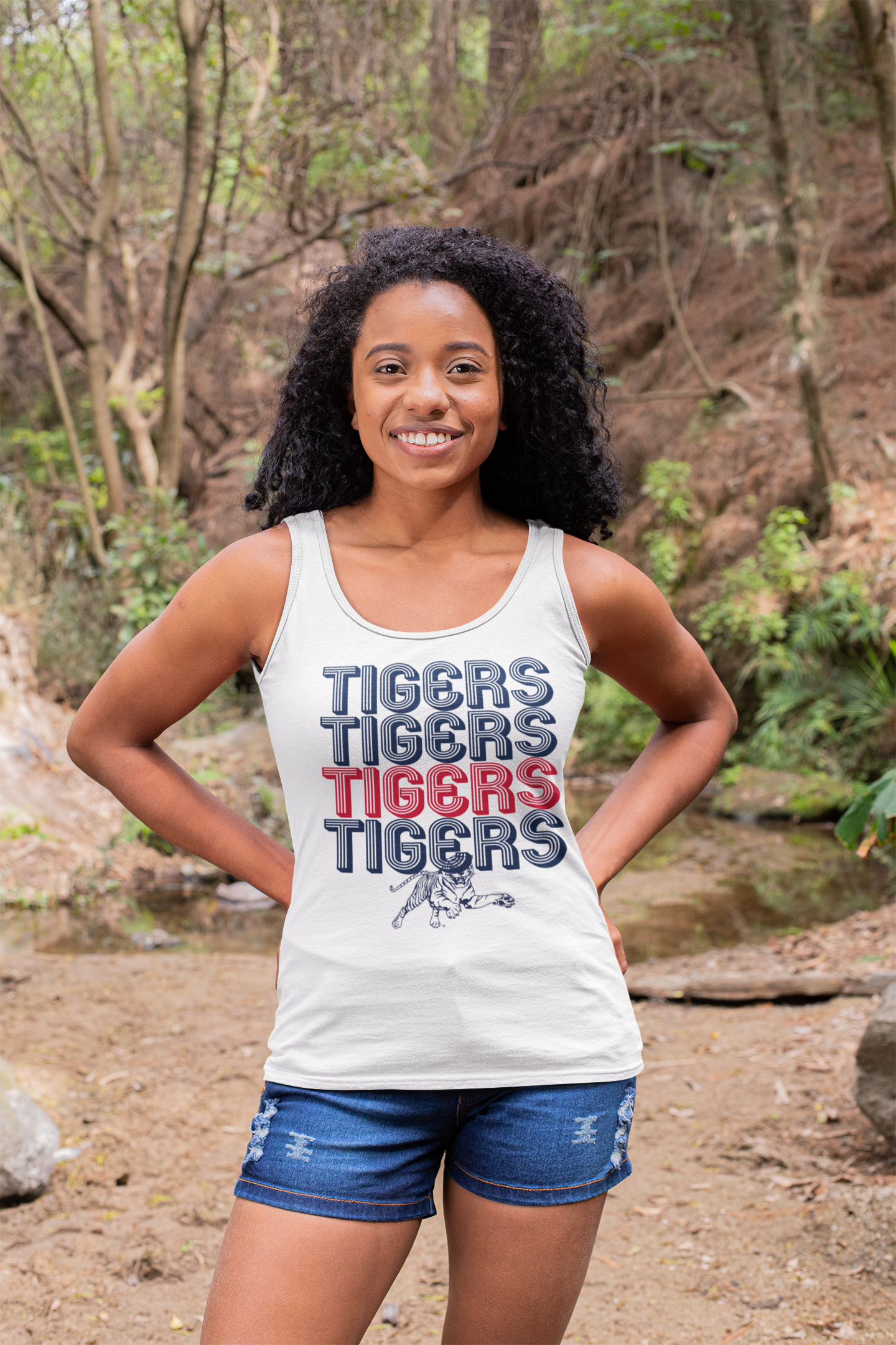 White graphic tank with multicolor TIGERS text and tiger mascot print, worn by model