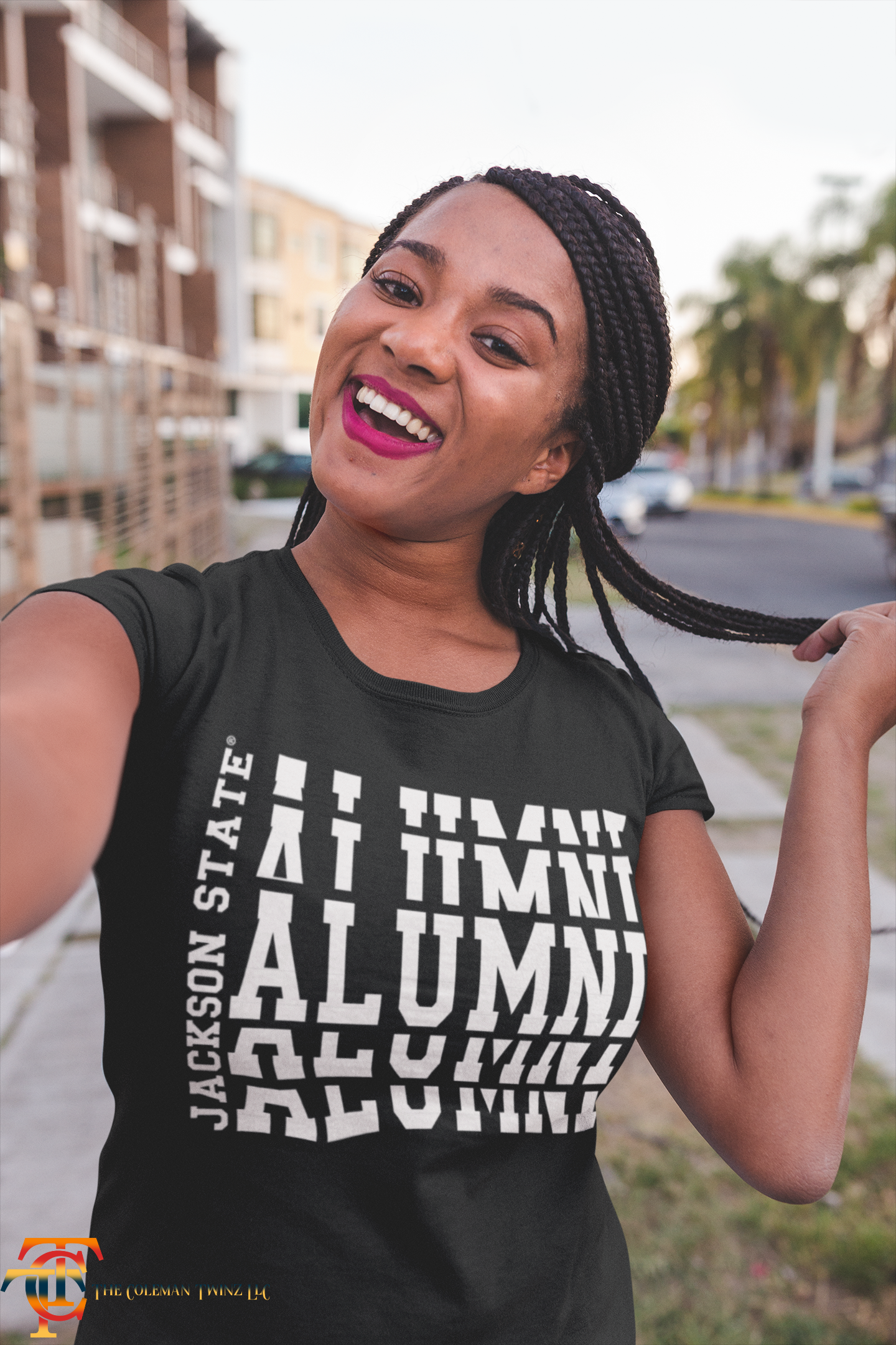 Black crew-neck short sleeve T-shirt with white stacked “Alumni” graphic on model