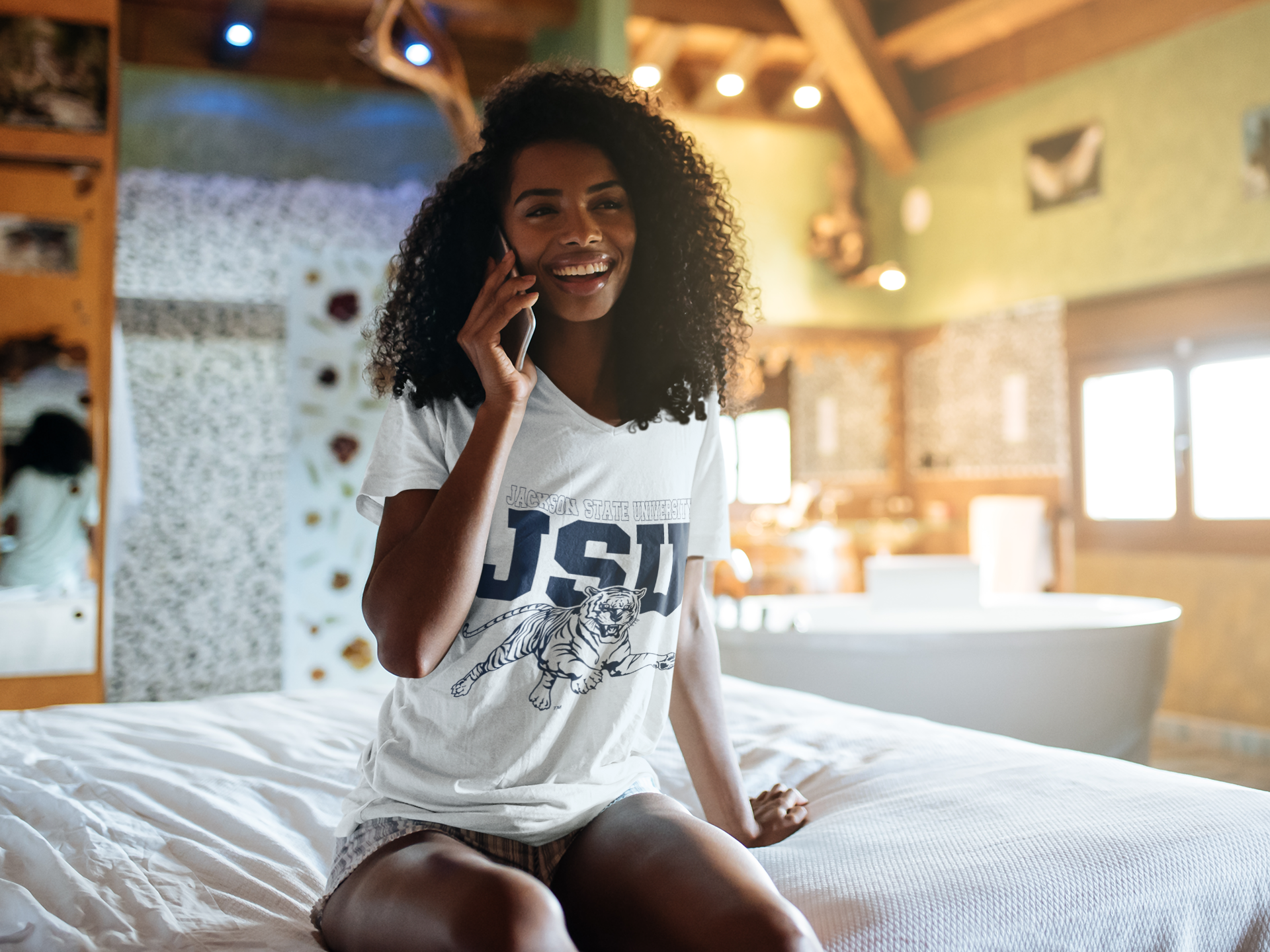 White V-neck T-shirt with JSU lettering and leaping tiger graphic, close-up on model
